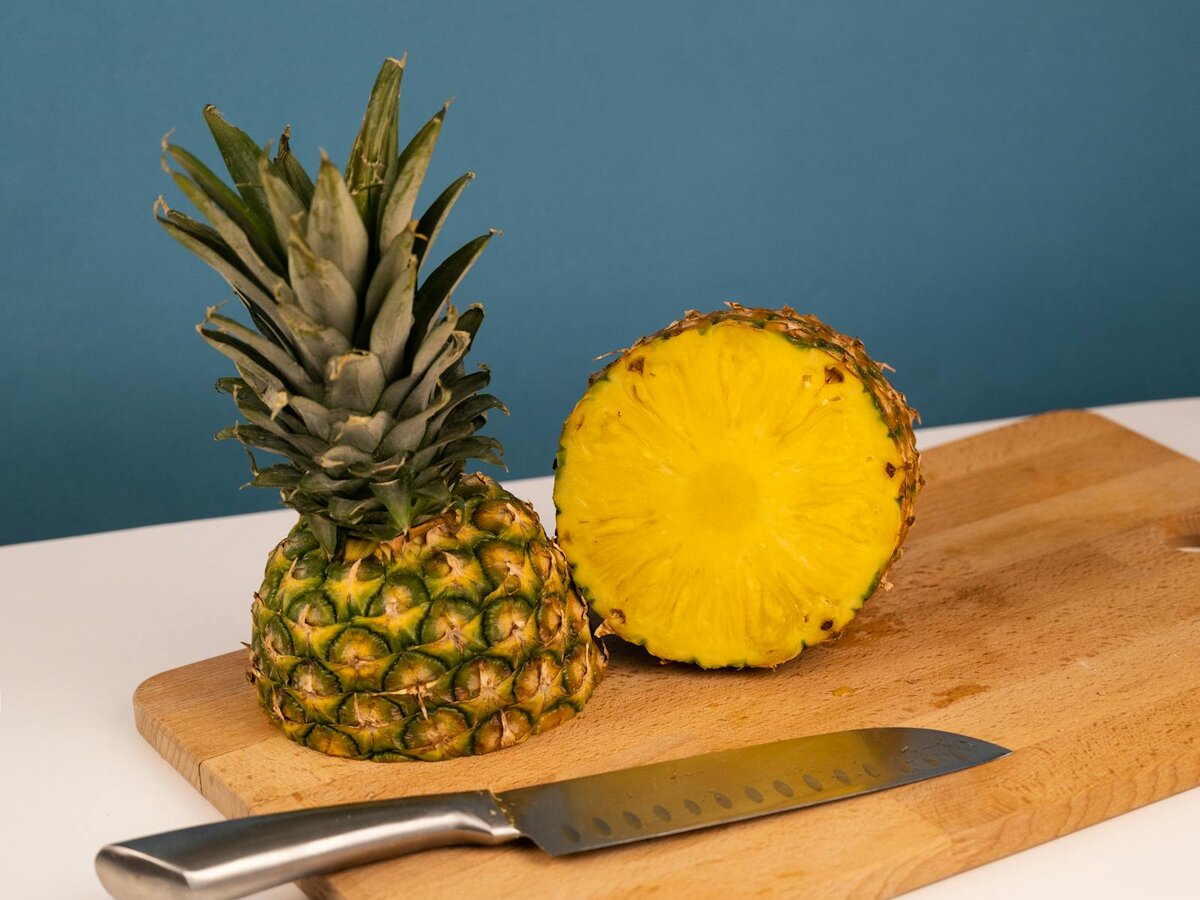 Ananas und Kochmesser auf einem Schneidebrett