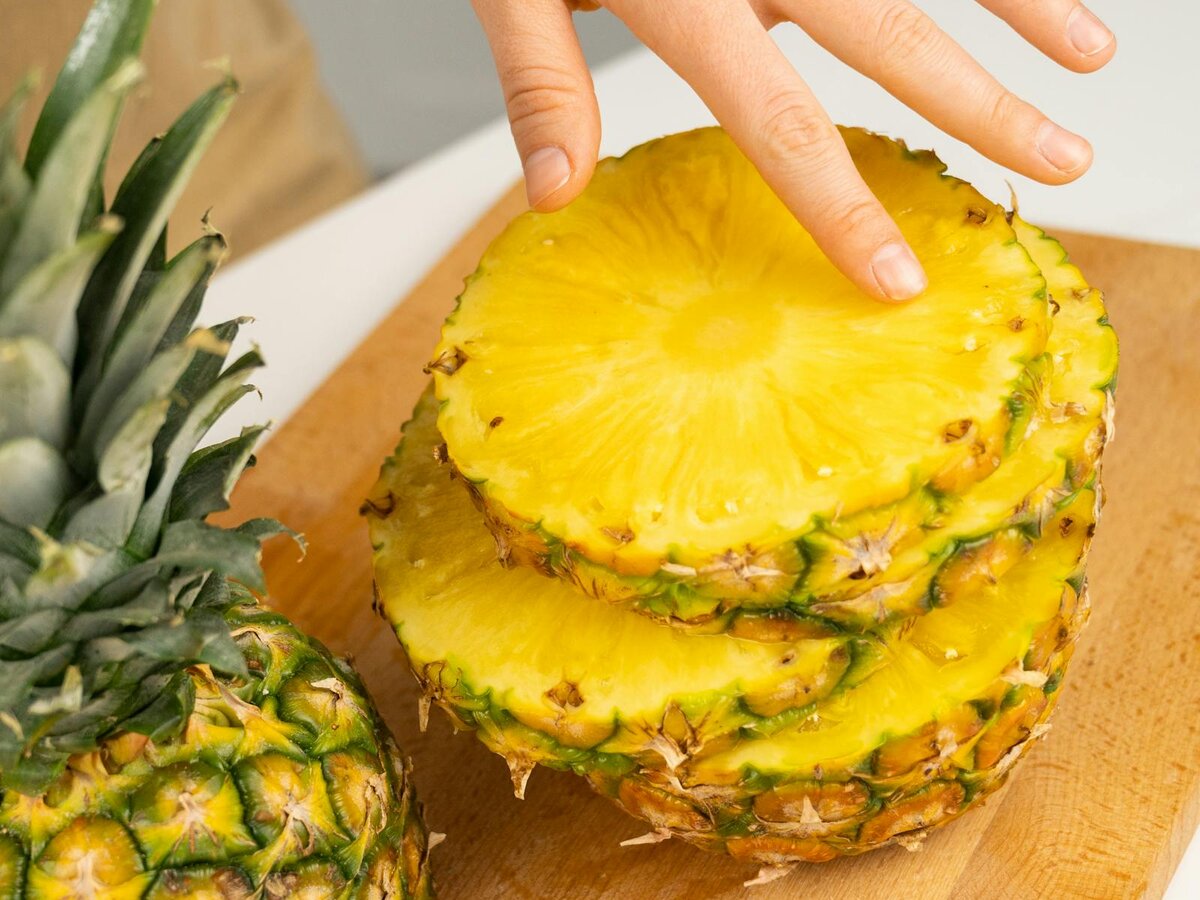 Ananas wird von Hand in Scheiben vorbereitet